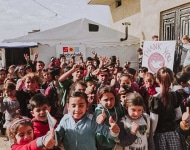 Glueckliche Schueler der Loewenschule aus einem Partyzelt