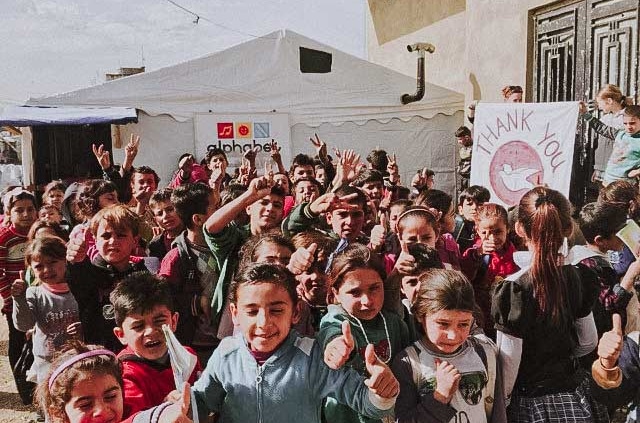 Glueckliche Schueler der Loewenschule aus einem Partyzelt